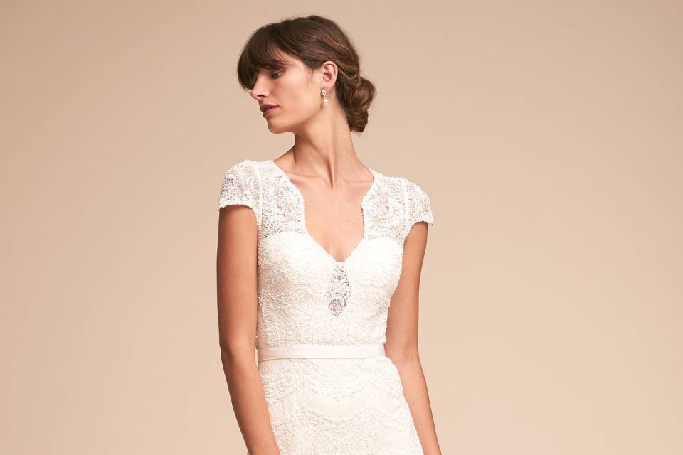 Watters	BHLDN Alice Gown	<br>	Playing with the graphic nature of embroidered lace, this design expertly uses negative space to create figure-flattering lines along its sleek silhouette. In motion, the flared skirt and long train add ethereal drama, while the corset construction of the sweetheart bodice creates a fitted feel.