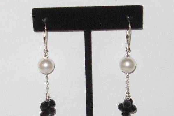 Sterling silver, with a SWAROVSKI  crystal in the jet shade and a white SWAROVSKI pearls. The crystal is a newer shape. They hand from a sterling silver chain.  It can also be made with 14 kt gold filled.
