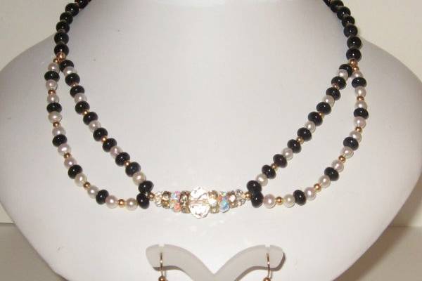 Black onyx and white pearls. SWAROVSKI CRYSTAL in the center is a clear A.B. shade. 14 kt gold filled beads and findings. The onyx is in two shapes. Perfect item for the bride who wants a black and white wedding.  This is a one only set.