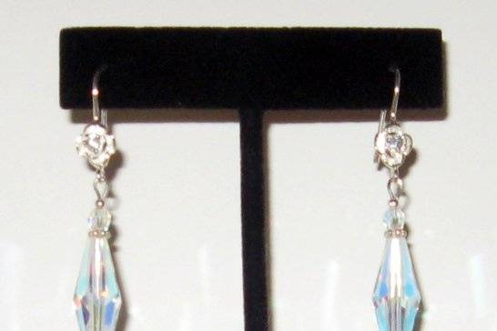 Mother of pearls pearl drops and SWAROVSKI crystal enlongated bicones.  Sterling silver roses with a rhinestone in the center.