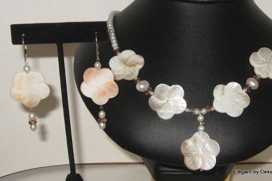 Mother of pearl flowers. flat backed large rice pearls, and a little glass beads in brownish shades. These are to show off the natural brown shades in the Mother of pearl flowers.