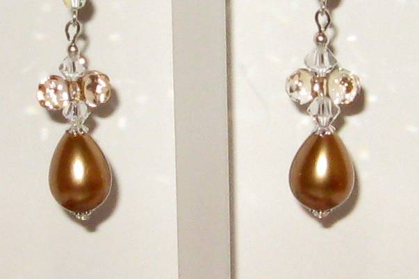 Golden pearl drops, brown rounds mother of pearl, pearls. The golden drop are Swarovski pearls. Clear new shapes of Swarovski crystal in clear A.B. all metal is sterling silver.