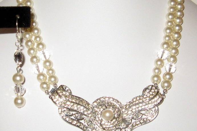 A beautiful rhinestone and pearl, rhodium plated center to this pearls and crystal necklace. The pearls and crystal are Swarovski. The ear wires have a marquise shaped CZ on the top.
