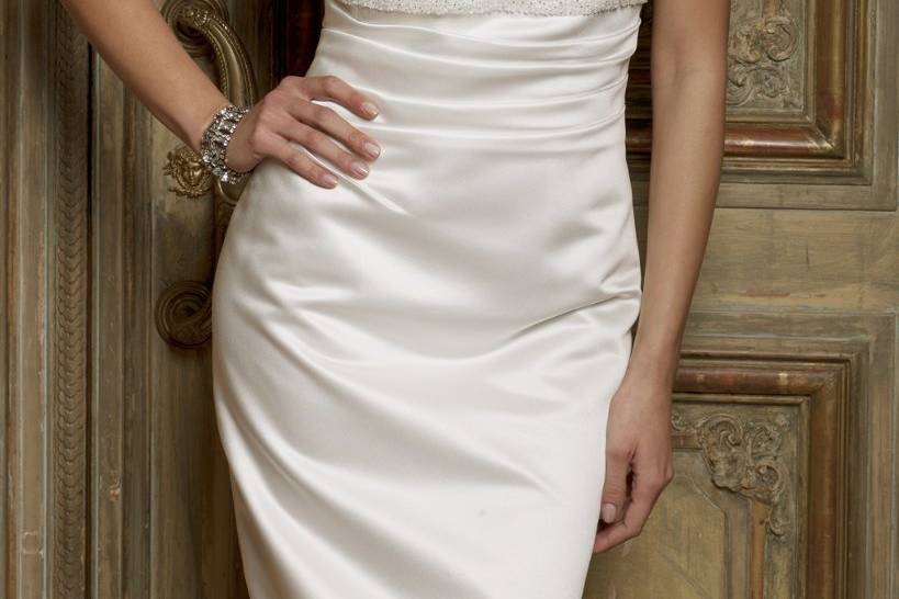 Style No. 41770_8285W <br>Keep it short, sleek and chic in this sharp and alluring wedding dress that manifests all the right amounts of elegance and class. This dress features a beautiful sweetheart neckline with a lovely beaded empire waist in the most luxurious fabric comprised of surplus satin. This wedding dress also comes with a matching jacket for an added dose of sophistication.