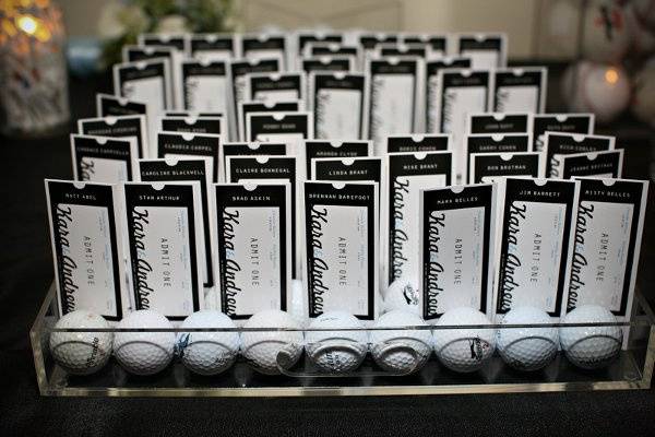 We designed an escort card, shaped like ticket stubs, display with golf balls for sports loving couple. Angela Gaeto Photography.