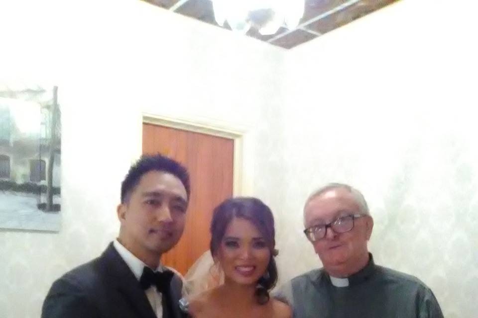 Newlywed couple with the officiant