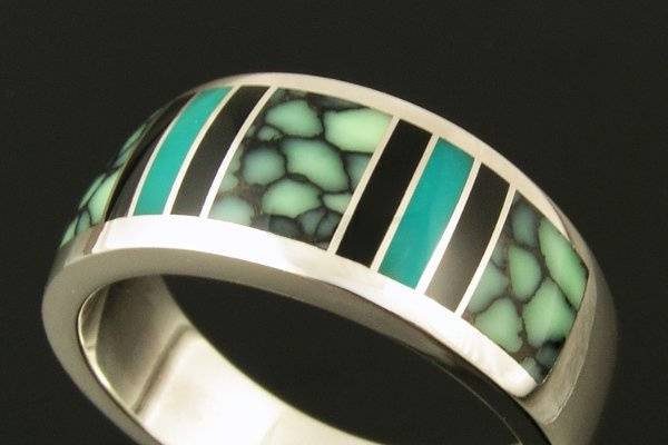 Bold man's sterling silver ring inlaid with black onyx, gem silica and chalcosiderite. Chalcosiderite is the green stone with the black webbing inlaid in the center and end sections. Chalcosiderite has similar properties to turquoise and it is often found near a turquoise formation. The blue stone between the black onyx pieces is gem silica. Gem silica is a very hard stone and is somewhat translucent. This ring measures 9.5mm wide and is a size 10 1/4. The ring is available in other sizes and stone choices by special order.