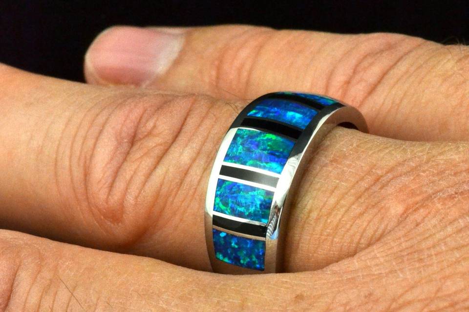 Man's wedding band in sterling silver inlaid with black onyx and lab created opal.  This band is 10mm wide and is available in other inlay materials and metals.