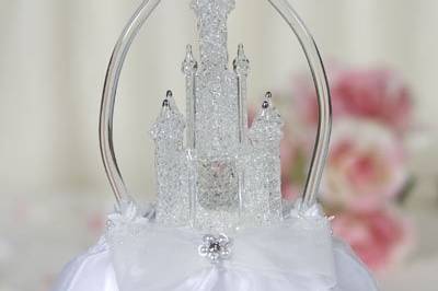 This beautiful wedding cake topper features an artisan made blown glass arch and castle accented with 24K white gold. Satin bow with faux pearl detail. Skirt is made of organza. Perfect for a Cinderella fairy tale themed wedding!
SKU: 100673
$60.00