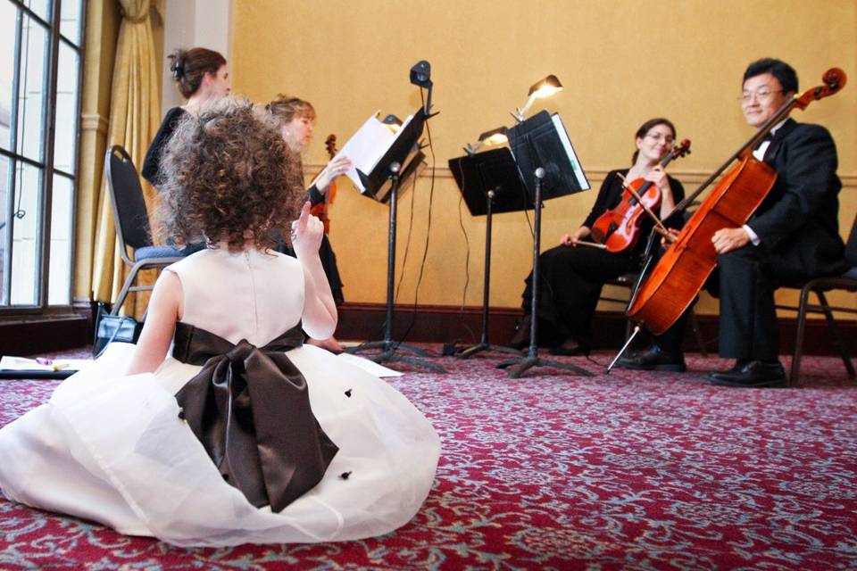 Flower girl watching the string quartet