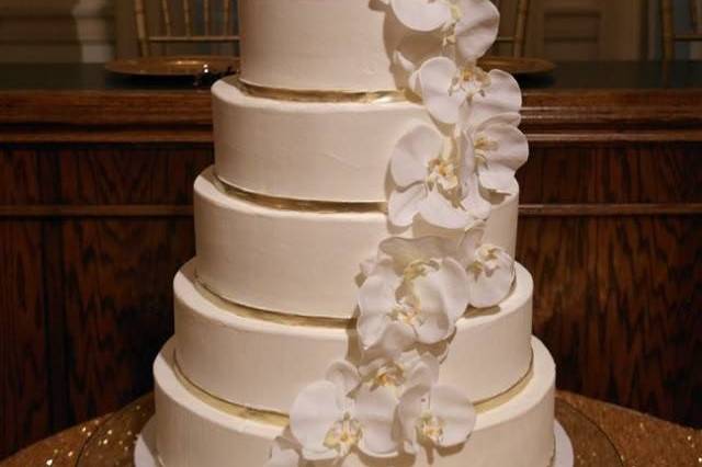 Plain white cake with ascending white flowers