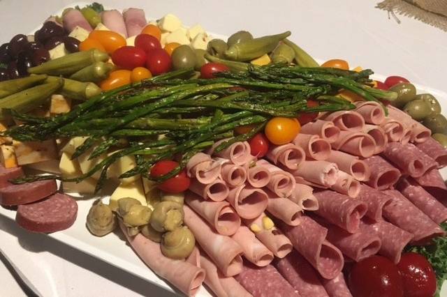 Antipasti Platter of rolled meats, artisan cheeses, olives, peppers, roasted asparagus and house made parmesan crackers.