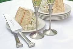 Sheer romance! This Flute and Wedding Cake Server Set embraces both grace and elegance. Set includes two toasting flutes, a cake cutter and a cake server. Both the servers and flutes feature an intricate heart shaped design decorated with a pearlized white border, sparkling crystal accents, and brushed silver finish. May be engraved with first names and wedding date at no additional charge. Flutes measure 11 tall.