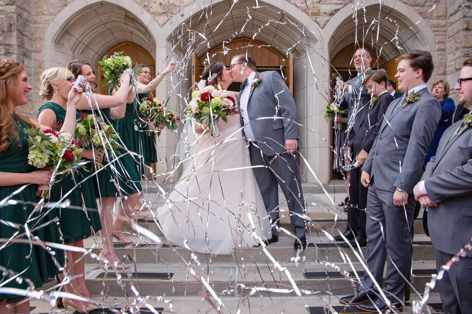 Excitement outside of a church with kissing couple.  Portrait Taken by Lovely Day Photo