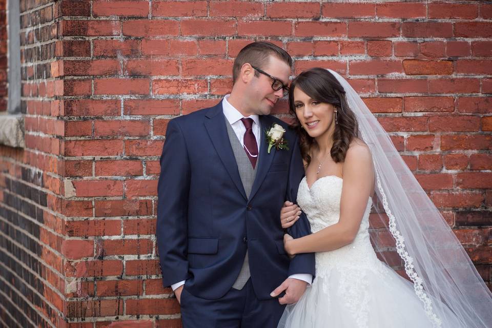 Photo taken by Lovely Day Photo of couple in Buffalo, New York with an urban brick background.