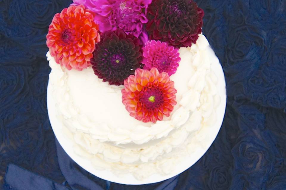 A colorful assortment of fresh dahlias add a beautiful statement to your special cake