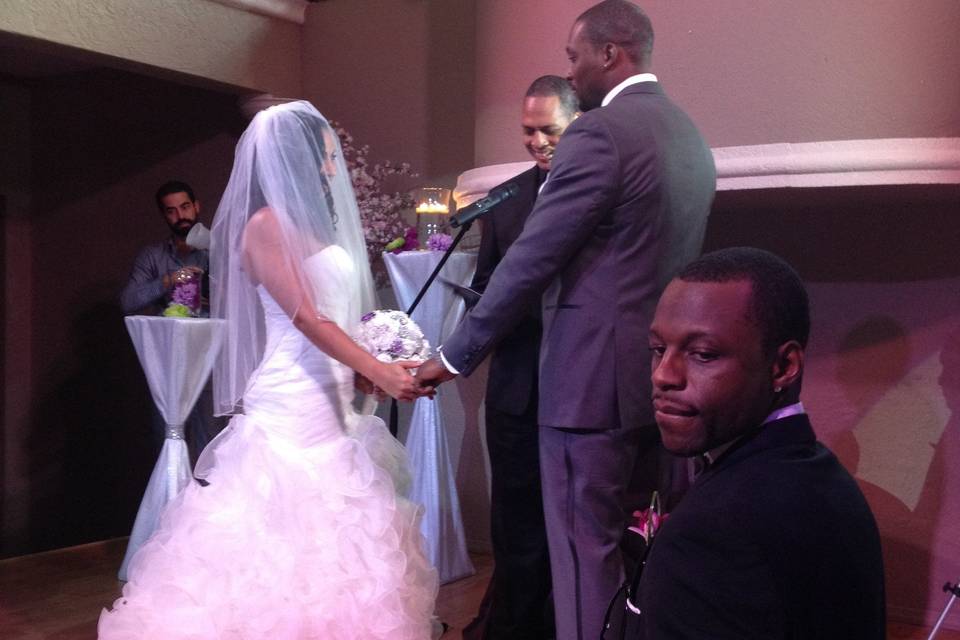 Beautiful bride and groom during the ceremony at the altar. Also visible is the best man, the groom's brother.A spectacular day