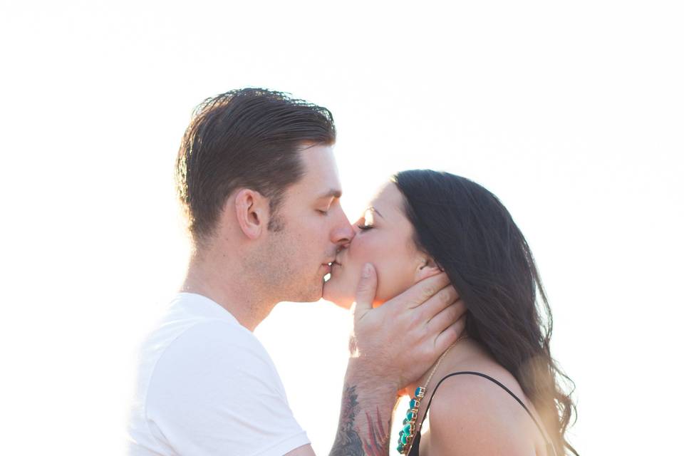 Couple kisses in a grassy field