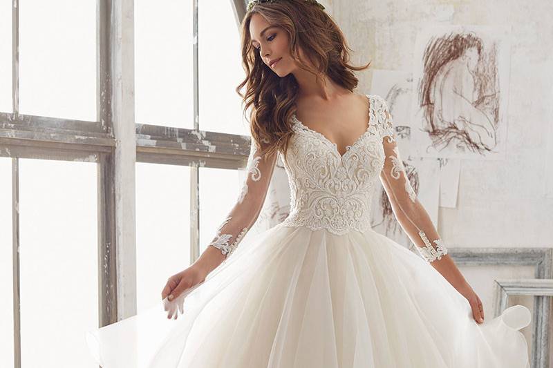 Maya, Style 5517	A Stunning Ballgown. Delicately Beaded, Alençon Lace Appliqués Adorn the Bodice and Illusion Sleeves, While Layers of Organza Create A Soft Dreamy Skirt. Available in: White, Ivory/Champagne.