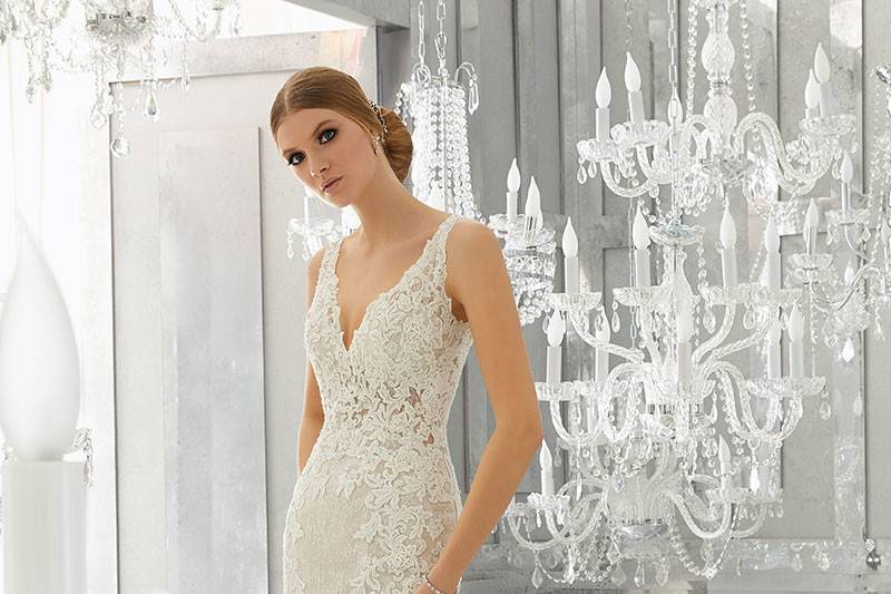 Mysteria, Style 8180	Layers of Net over Chantily Lace & Sequined Tulle Create This Wedding Gown. Crystal Beaded, Embroidered Appliqués Accent the Sheer Bodice. Deep-V Open Back . Available in: White, Ivory, Nude.