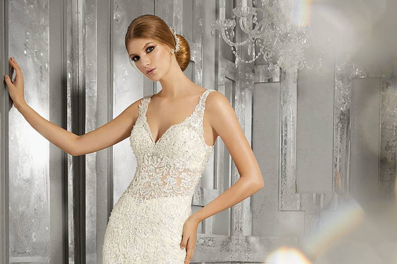 Maggie, Style 8192	Embroidered Appliqués with Crystal Beading Accent the Sheer Bodice on This Luxurious Fit and Flare Gown. Scalloped Hemline and Open Back. Lining Included. Available in: White, Ivory, Ivory/Light Gold.