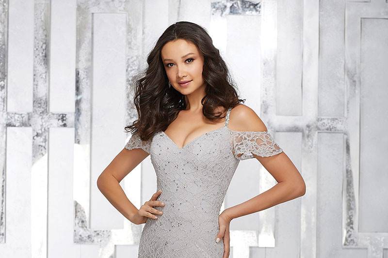 Style 21531		Chic Full Length Lace Bridesmaids Dress with beading Featuring a Cold Shoulder V Neckline and Scoop Back. Covered Buttons Along the Back Complete the Look. Shown in Silver.  Available in 13 colors.