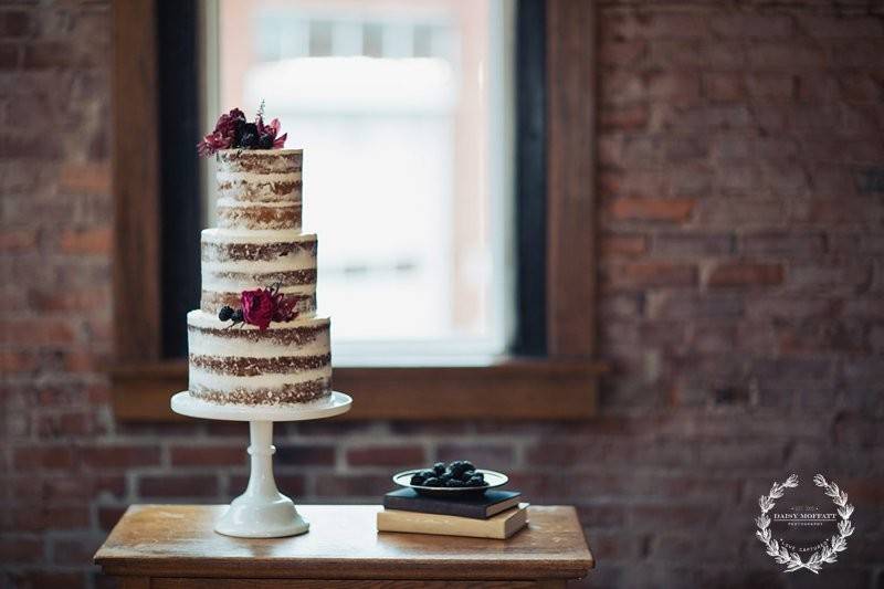 Naked wedding cake covered in berries