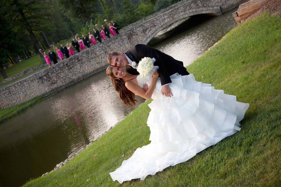 Bride and Groom with wedding party near the stone bridge