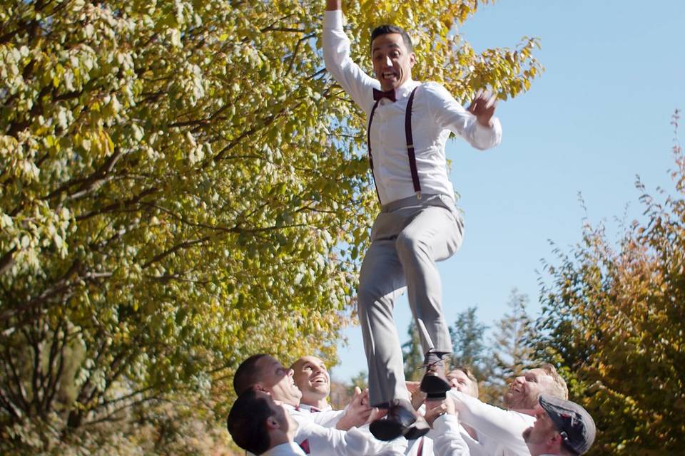 Groomsmen lift up the groom