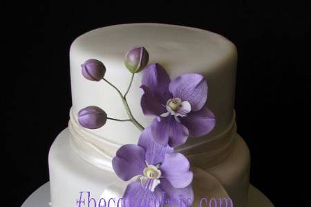 Fondant two tier cake with sugar sash, ribbon and pearls. Lilac Vanda orchids are also hand-molded out of sugar-paste.