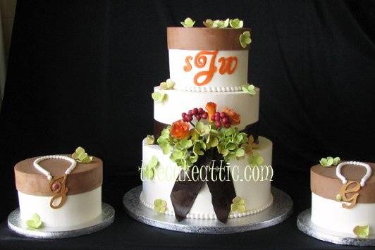 Buttercream cake with fondant sash and sugar flowers. Sides cake have sugar necklaces with the initials of the bride's two new stepdaughters.