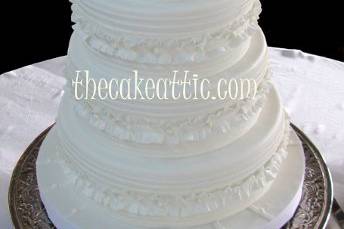 Ruffled and pleated cake with small buttons. Covered in fondant with sugar paste decorations.