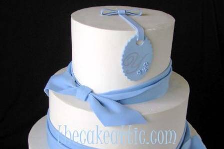 Buttercream cake decorated with sugar sash and ties. Topped off with a monogrammed sugar tag.