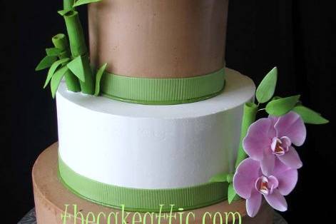 Buttercream cake decorated with sugar ribbons, bamboo and orchids.