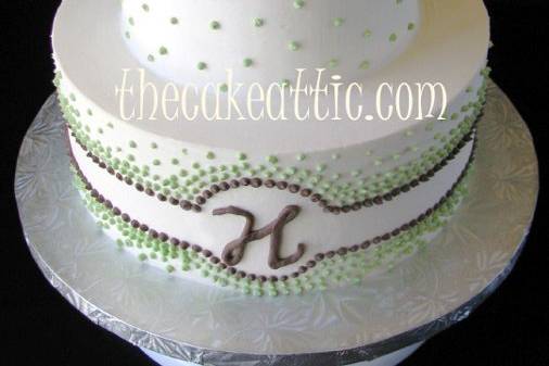 Buttercream cake with a piped buttercream design in chocolate brown and green.