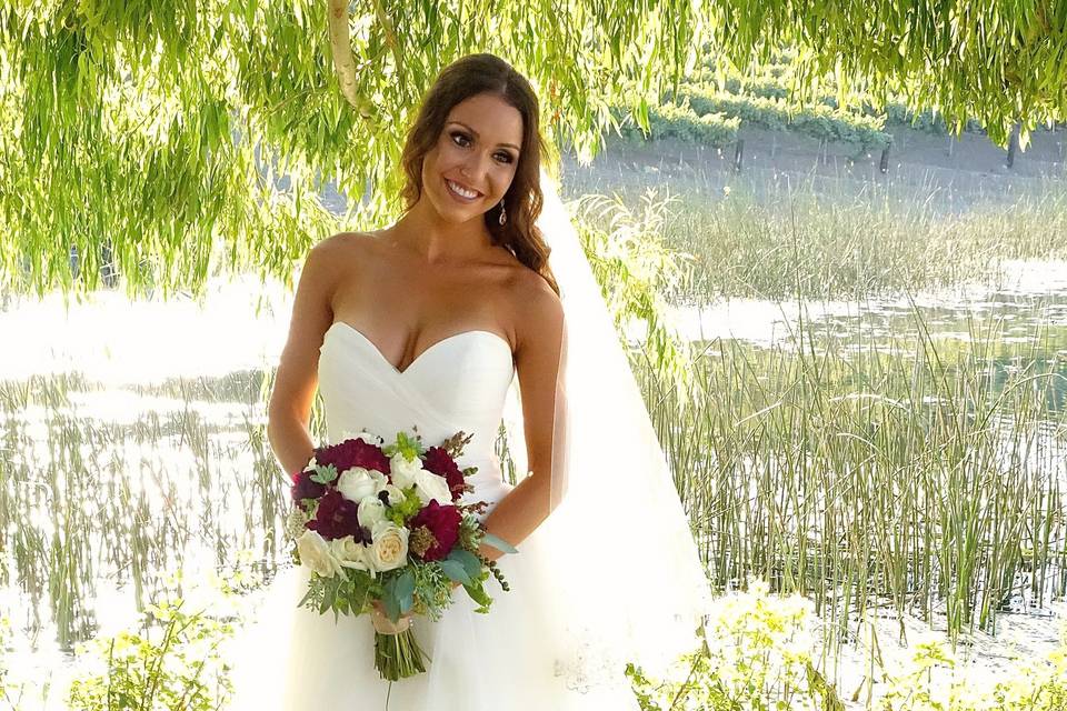 Bride on the shore of the pond at Leal Vineyard, Hollister, California.