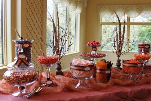This lovely candy buffet pays homage to autumn without going over the top.  Lovely hues of orange and chocolate brown, twig lights, and pheasant feathers are key elements.