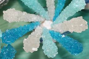 Cotton Candy, Blue Raspberry, and Natural Rock Candy sticks swirl in a bed of sugar.