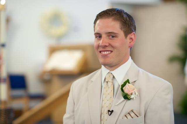 The pensive groom.  A classic rose boutonniere with accents of stephanotis.