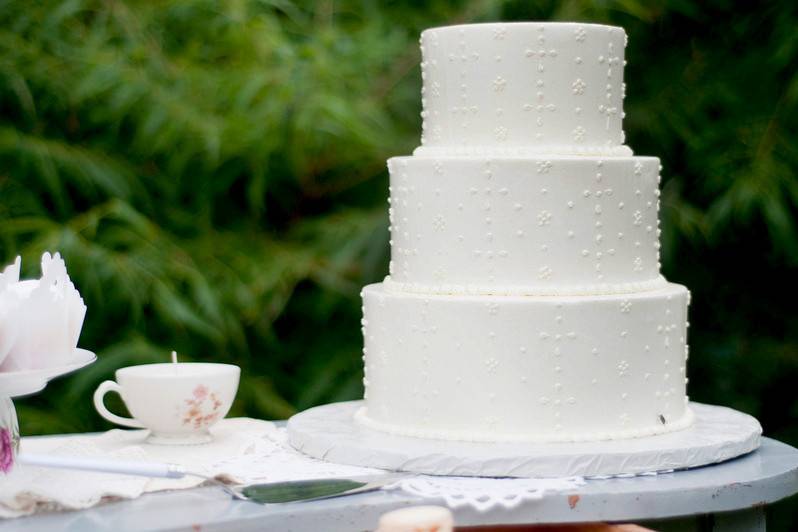 A classic three tiered cake with simple yet delicate lace decoration.