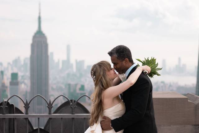 Rooftop romance at 620 Loft & Garden, NYC – the couple embraces on an elevated terrace with the stunning NYC skyline as their backdrop.