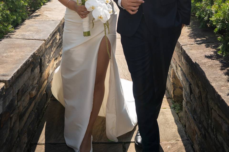 Walking portrait at 620 Loft & Garden, NYC – the couple walks hand-in-hand through the beautiful gardens with New York City's skyline surrounding them.