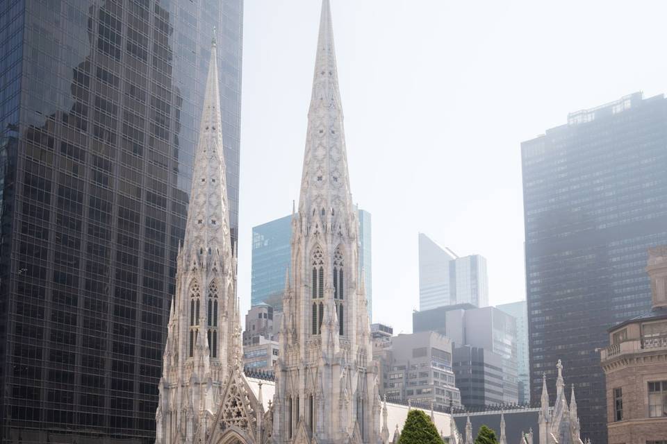 Garden portrait at 620 Loft & Garden, NYC – the couple strolls through the vibrant gardens with a stunning cathedral view and colorful blooms.