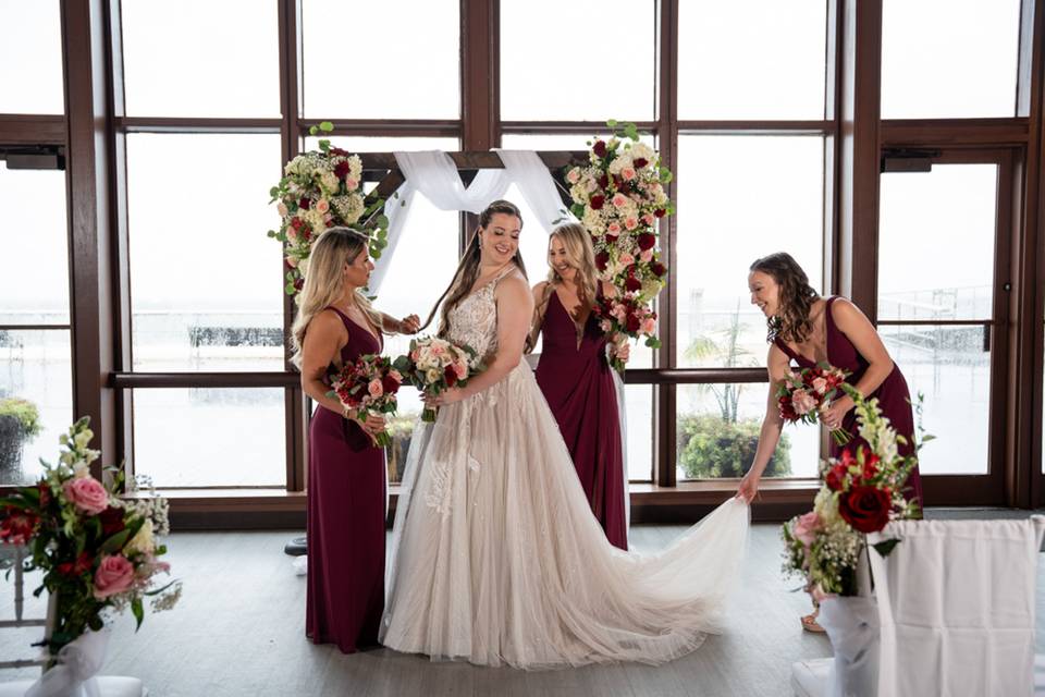 Bridal party at Pavilion at Sunken Meadow, NY – the bride stands beautifully with her bridesmaids in deep burgundy gowns at the waterfront venue.