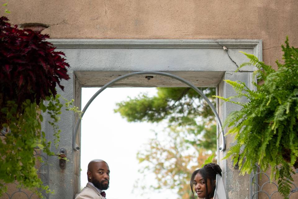 Romantic portrait at Untermyer Gardens, Yonkers, NY – the couple shares a tender moment at the garden gate, surrounded by lush greenery and natural beauty.