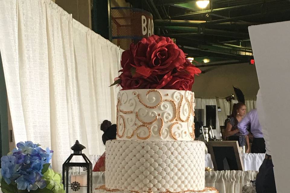 Wedding cake with red roses on top