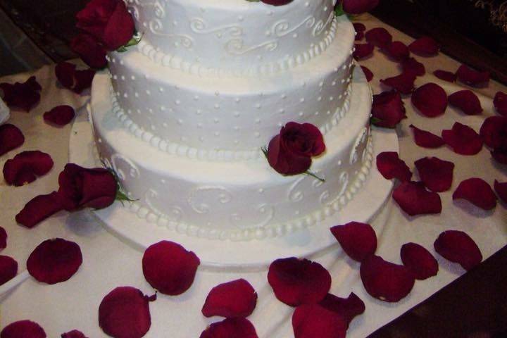 White wedding cake with rose petals