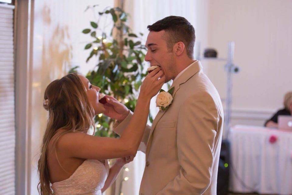 Newlyweds feeding each other cupcakes