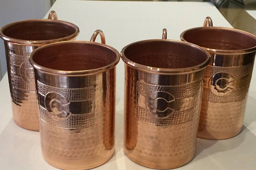 Colorado State Flag hand engraved Moscow Mule Mugs. Handcrafted, hammered pure copper. We offer sizes ranging from 10oz-24oz in a variety of shapes.  We can hand engrave your mugs to fit your wedding and vision.