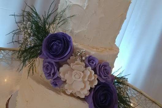 Three-tier wedding cake with purple flowers